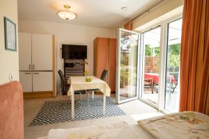 a living room with a table and a sliding glass door at Apartments im Garten - Haus Daniela in Graz