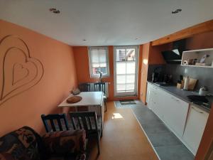 eine Küche mit orangefarbenen Wänden und einem Tisch mit einem Herz an der Wand in der Unterkunft Ferienwohnung Camino in Jockgrim