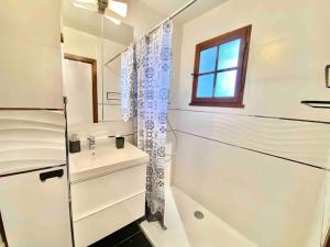 a white bathroom with a sink and a shower at HAMEAU 4 pax Plage Piscine in Saint-Raphaël