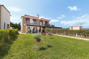 a house with a yard with two potted plants at Villa Orelia in Hanioti