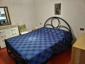 un letto blu in una stanza con cassettiera e specchio di Villetta Pinus Village Residence a Pula