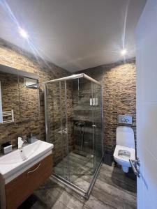 uma casa de banho com um chuveiro, um WC e um lavatório. em Deluxe Beach Residence em Samsun