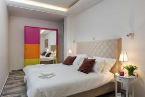 1 dormitorio con 1 cama blanca grande y pared colorida en Apartments with a parking space Mlini, Dubrovnik - 8566, en Mlini