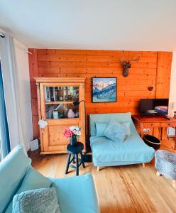 a living room with a blue couch and a wooden wall at Chalet-Apartment Seefeld and Chill HARMONY im Zentrum mit Netflix for free in Seefeld in Tirol