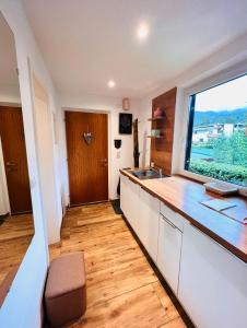 a kitchen with a counter and a sink and a window at Chalet-Apartment Seefeld and Chill HARMONY im Zentrum mit Netflix for free in Seefeld in Tirol