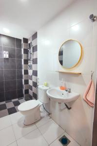 a bathroom with a toilet and a sink and a mirror at Ipoh Homestay - Manhattan Condominium with Water Park & Leisure Facilities in Ipoh