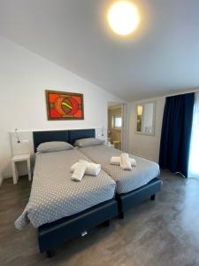 a bedroom with two beds with towels on them at Hotel Aurora & Appartamenti in Nago-Torbole