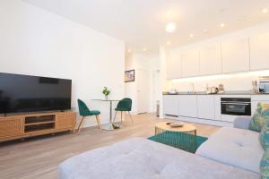 ein Wohnzimmer mit einem Sofa und einem TV sowie eine Küche in der Unterkunft Alliance 209 in Bristol