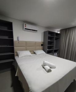 a bedroom with a large white bed with two towels on it at Get One in Tambaú