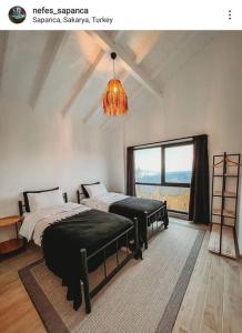 a bedroom with two beds and a chandelier at Nefes Vılla Sapanca in Sakarya +45 photos