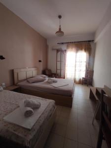 1 dormitorio con 2 camas y ventana en House Mistral, en Neos Marmaras
