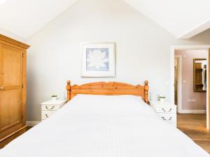 a bedroom with a large bed with white sheets at Pass the Keys Quality Rural 2 Bed Cottage Retreat in Warwick
