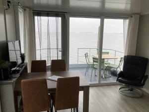 a dining room with a table and a view of the ocean at Houseboot Cormorant, lake view in Biddinghuizen