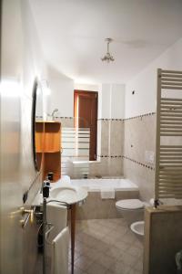 ein Badezimmer mit einer Badewanne, einem WC und einem Waschbecken in der Unterkunft B&B Il Grifone in Gioia del Colle
