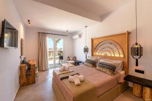 ein Schlafzimmer mit einem großen Bett und einem großen Fenster in der Unterkunft Le Palme Mykonos in Klouvas