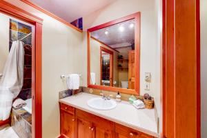 a bathroom with a sink and a mirror at Snow Leopard's Retreat in Big White +12 photos