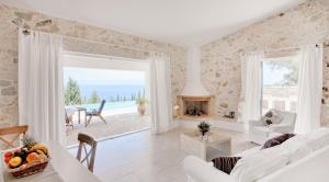 a white living room with a view of the ocean at Monodendri Blue in Georgoutsátika +6 photos