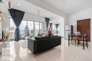 a person sitting on a couch in a living room at Wonderful KLCC View at Regalia Suites in Kuala Lumpur