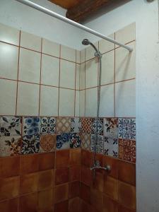 baño con ducha con azulejos en la pared en Camino & Piedra - Cabaña de Montaña en Potrerillos