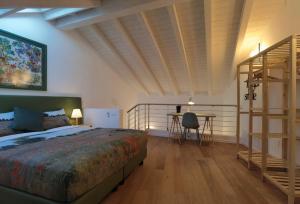 a bedroom with a bed and a desk and a ladder at Vivila - Ca' Foulard in Cernusco sul Naviglio