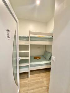 Appartements neuf - Frontière de Monaco - clim - WIFI في كاب دايل: غرفة صغيرة مع سرير بطابقين وثلاجة