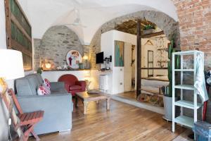 een woonkamer met een bakstenen muur en een bank en een tafel bij Green Cactus House in La Spezia