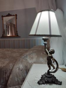 eine Lampe auf einem Tisch neben einem Bett in der Unterkunft Bouquet di Note in Cervo