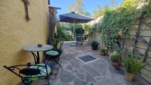 a patio with a table and an umbrella at Maison Ambre Guesthouse in Windhoek