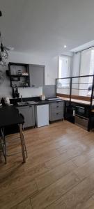 duża kuchnia z drewnianą podłogą i stołem w obiekcie Appartement chaleureux en Ardèche w mieście Châteaubourg +7 zdjęć
