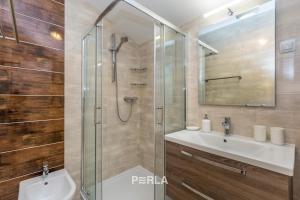 Un baño con ducha de cristal y lavabo. en Apartment house BRINY, en Pinezici 35 fotos más