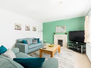 ein Wohnzimmer mit einem Sofa und einem TV in der Unterkunft Pass the Keys Self Contained 2 Bed with Parking Leamington Spa in Leamington Spa