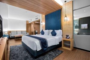 una camera d'albergo con un grande letto e un bagno di ASTON Sidoarjo City Hotel & Conference Center a Sidoarjo