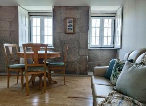 a living room with a table and chairs and a couch at Casa Recanto do Teatro in Lamego