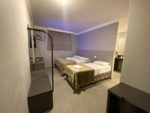 2 camas en una habitación con iluminación púrpura en Hotel PrimeInn, en Campinas