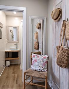 a bathroom with a chair with a pillow and a mirror at Casa Recanto do Teatro in Lamego