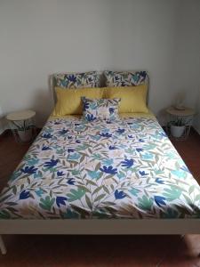 een bed met een bloemdekbed en 2 kussens bij VillasMC in Alpalhão