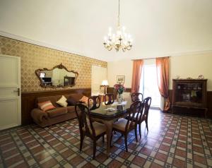 un soggiorno con tavolo, sedie e divano di I Balconi sul Barocco a Modica