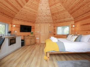 a bedroom with a large bed in a wooden cabin at Honeybee Retreat in Pentney