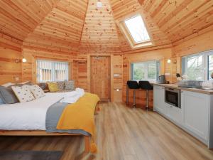1 dormitorio con 1 cama en una cabaña de madera en Honeybee Retreat, en Pentney