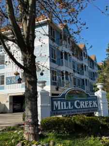 um edifício com uma placa de moinho em frente a uma árvore em Mill Creek Hotel em Lake Geneva