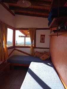 1 dormitorio con cama y ventana en Camino & Piedra - Cabaña de Montaña en Potrerillos