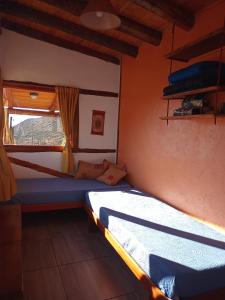 a bedroom with two beds and a window at Camino & Piedra - Cabaña de Montaña in Potrerillos
