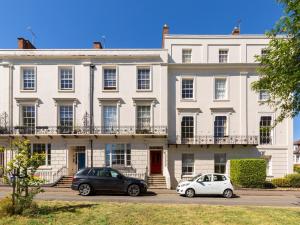 deux voitures garées devant un bâtiment blanc dans l'établissement Pass the Keys Central Leamington Spa 2 Bed Flat with Parking, à Leamington Spa