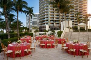 un grupo de mesas y sillas con manteles rojos en The St. Regis Bal Harbour Resort en Miami Beach