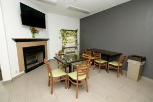 a dining room with a table and chairs and a fireplace at HomeTown Inn-Ringgold in Ringgold