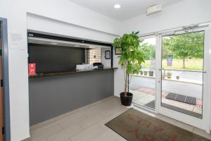 a room with a potted plant and a sliding glass door at HomeTown Inn-Ringgold in Ringgold