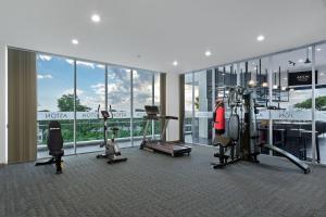 un gimnasio con cintas de correr y equipos de ejercicio en un edificio en ASTON Sidoarjo City Hotel & Conference Center en Sidoarjo