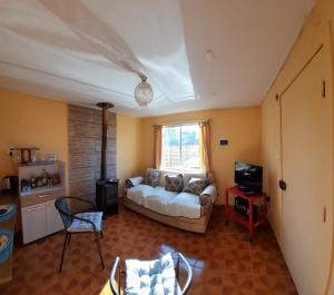 sala de estar con sofá y TV en Cabana Quillon, en Quillón
