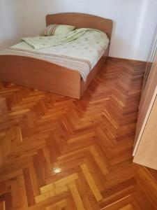 a bedroom with a bed and a wooden floor at Šumadijska panorama in Topola