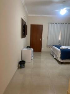 a bedroom with a bed and a television in it at Pousada Cachoeira do Sol in Jaboticatubas